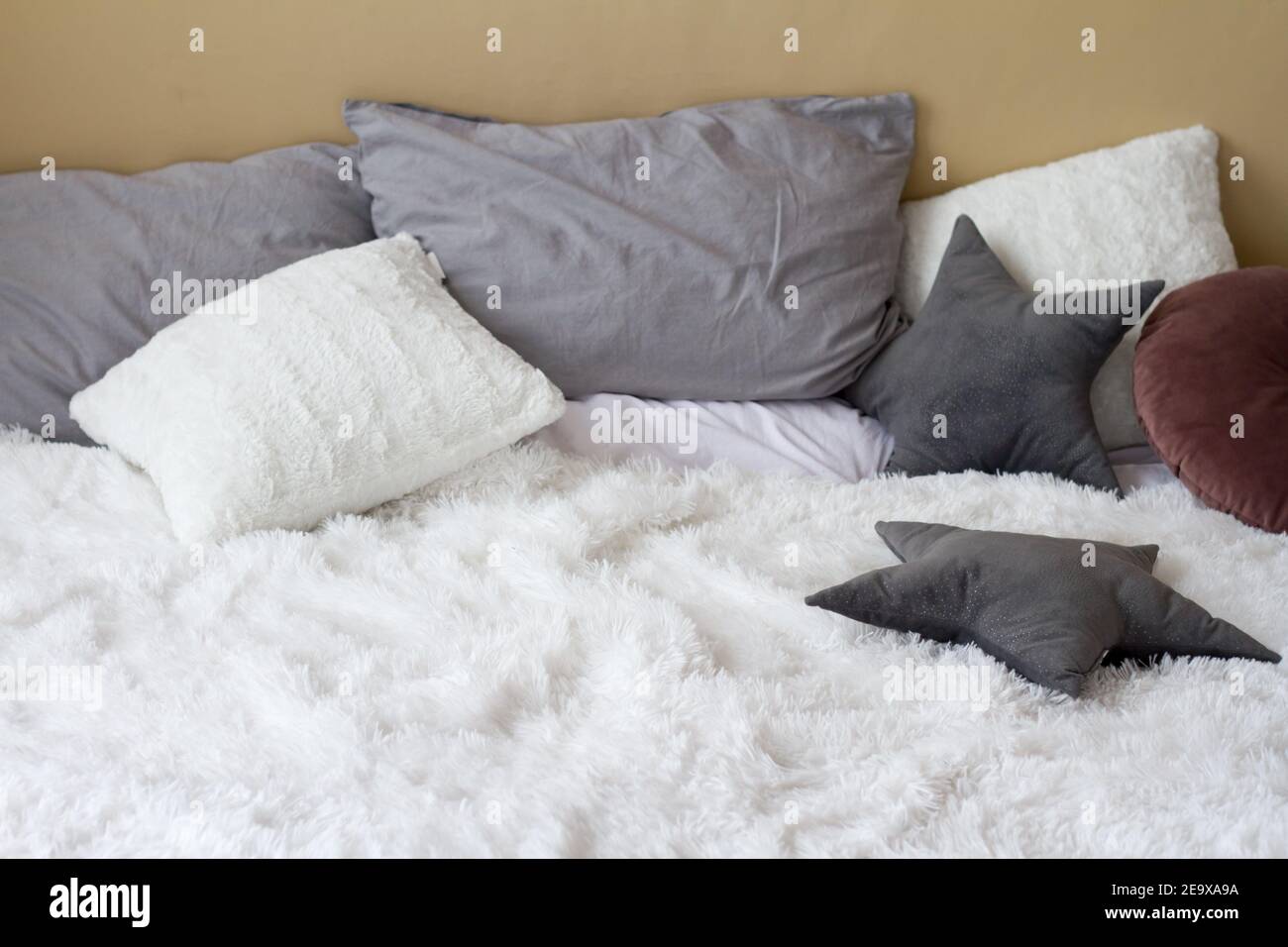 Komfortables Bett mit Kissen im hellen Schlafzimmer, Komfort-Konzept für Zuhause, Kopierer Stockfoto