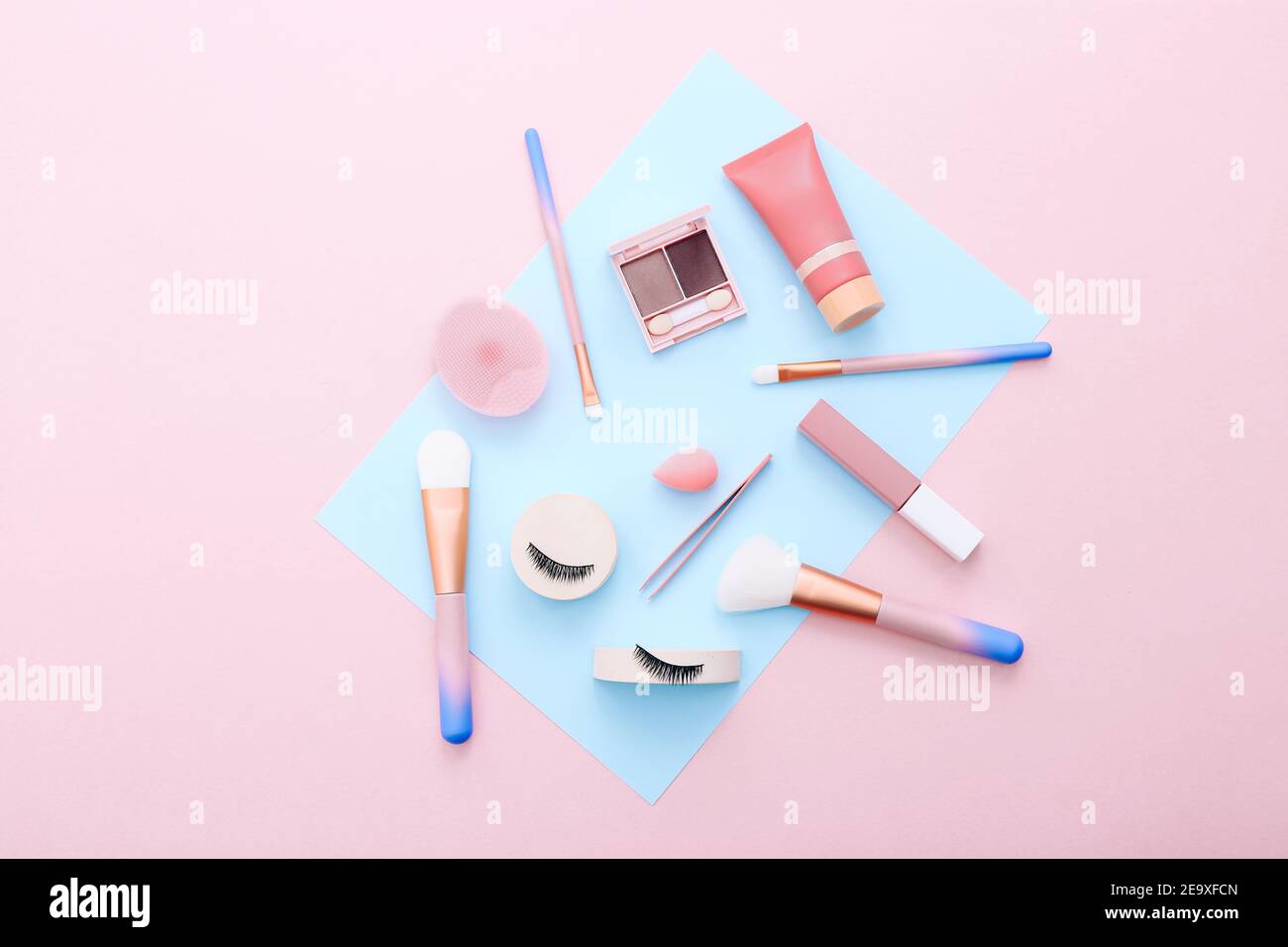 Make-up Werkzeuge und Zubehör auf blauem und pinkem Hintergrund. Schönheitskonzept. Flache Lay-Komposition, Draufsicht Stockfoto