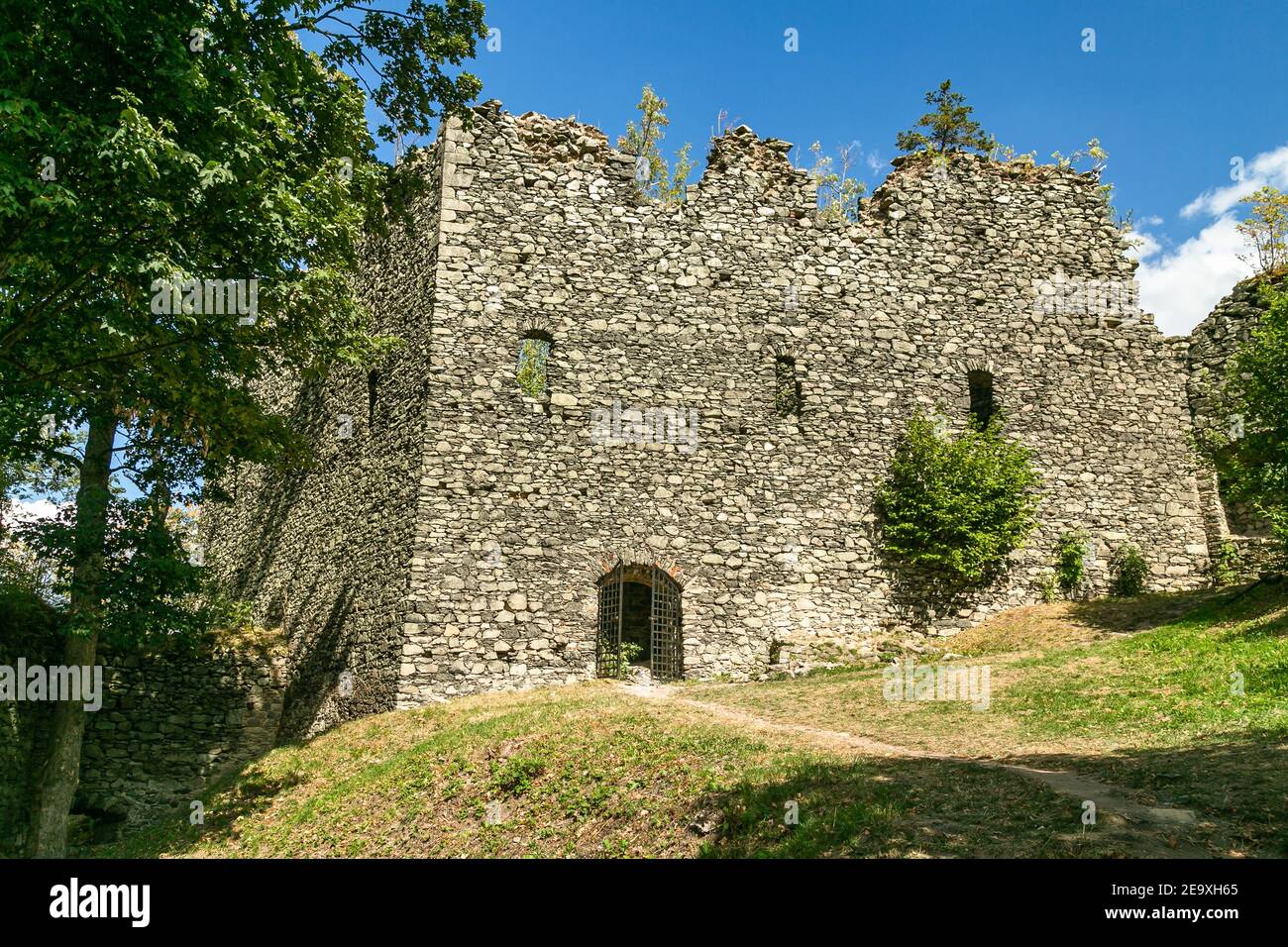 Andelska hora, Tschechische Republik - August 11 2018: Überreste der Steinburg aus dem 15th. Jahrhundert, die auf einem Hügel mit grünen Bäumen und trockenem Gras steht. Stockfoto