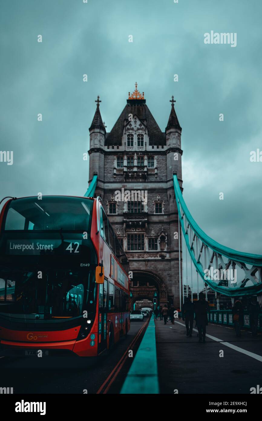 London UK Januar 2021 Vertikale Aufnahme der Tower Bridge während der nationalen Lockdown der britischen Regierung. Roter Doppeldeckerbus, der an der Brücke vorbeifährt Stockfoto