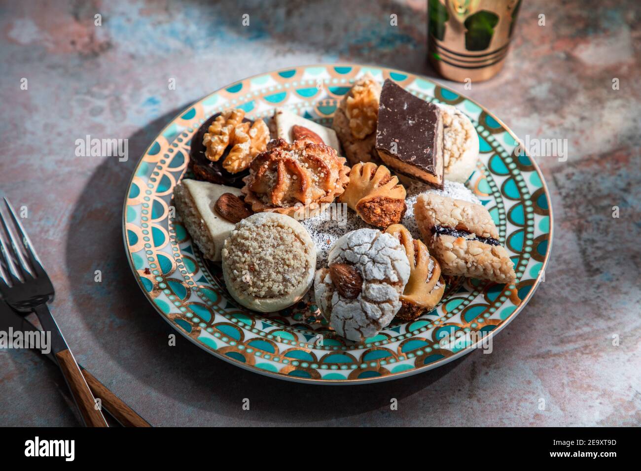 Von oben Baklava und Kekse mit marokkanischen Pfefferminztee In der Nähe Messer und Gabel auf Tisch mit Minze verziert platziert Blätter Stockfoto