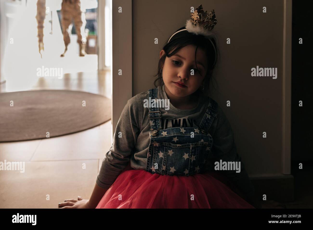 Kleine hoffnungslose Mädchen trägt festliche Kleid und Krone wartet auf Vater kommt aus dem Militärdienst Stockfoto
