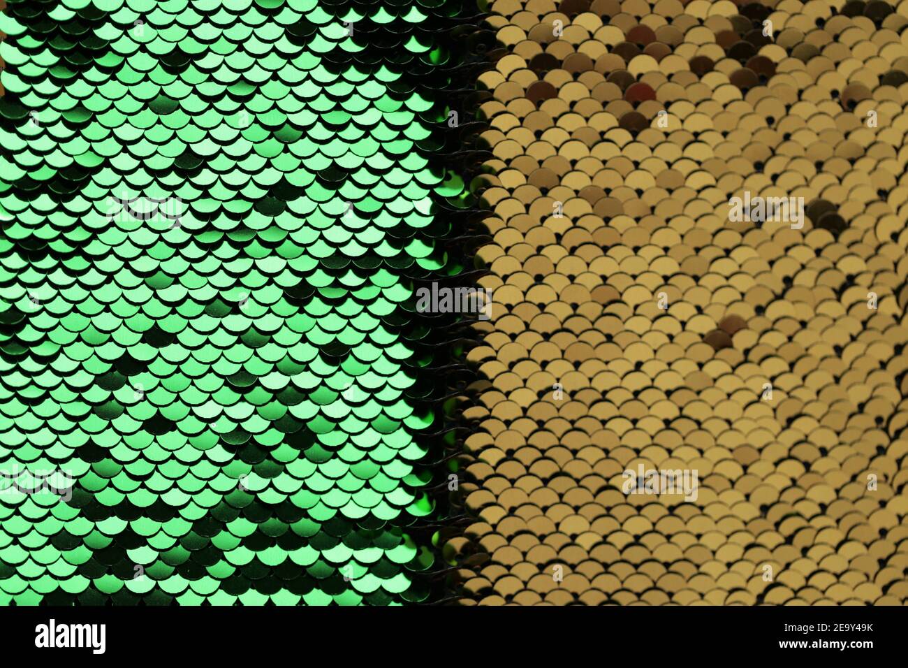 Pailletten Hintergrund Grün und Gold Pailletten halb Hintergrund. Lebendige Makro Schimmer Textur. Glänzend Stoff. Glitter Materialstruktur Stockfoto