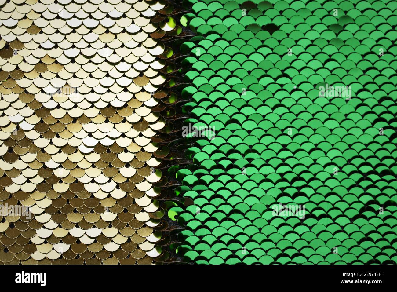 Pailletten Hintergrund Grün und Gold Pailletten halb Hintergrund. Lebendige Makro Schimmer Textur. Glänzend Stoff. Glitter Materialstruktur Stockfoto