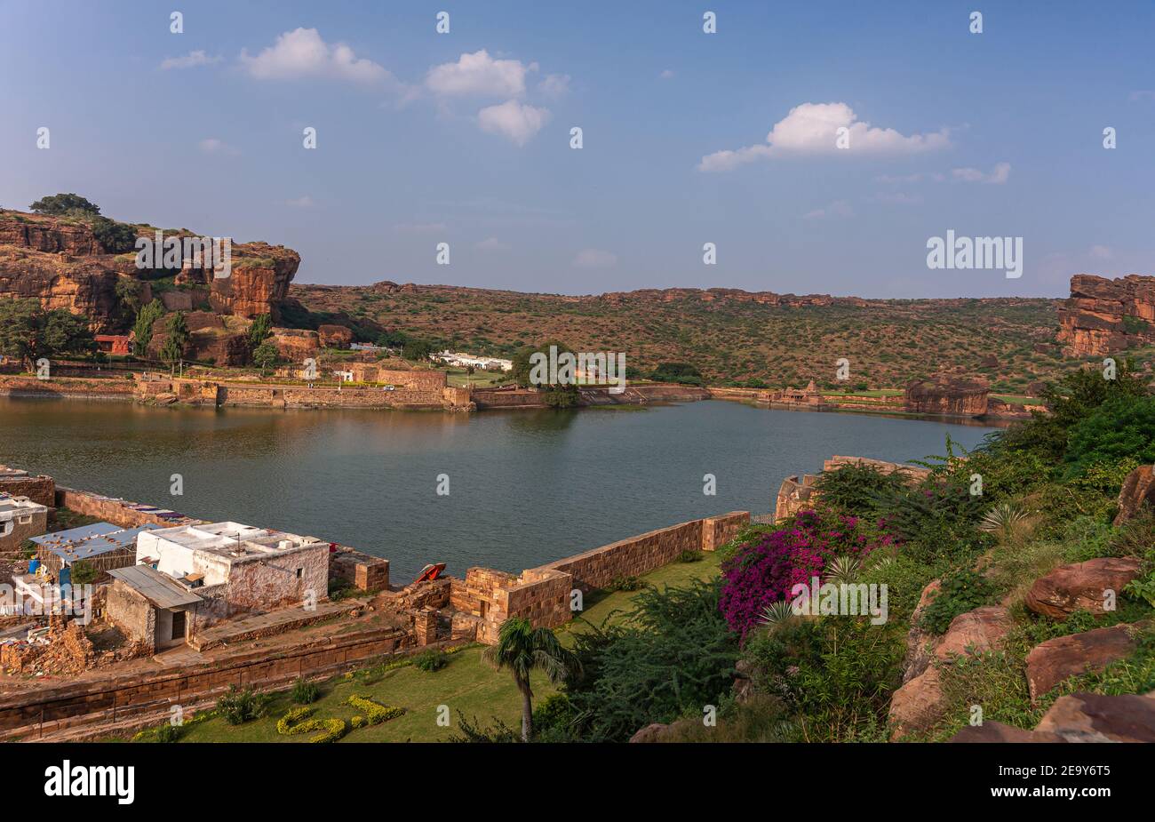 Badami, Karnataka, Indien - 7. November 2013: Höhlentempel über dem Agasthya See, wie gezeigt, umgeben von Hügeln, Felsen und Klippen unter blauer Wolkenlandschaft. Stockfoto