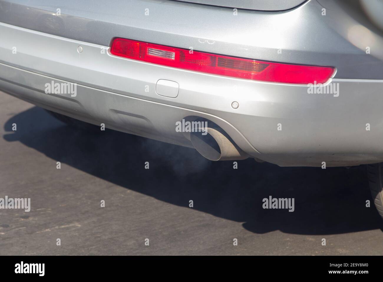 Der Kraftverkehr verschmutzt die Luft in den Städten. Der Rauch wird aus einem Auspuffrohr austritten. Stockfoto