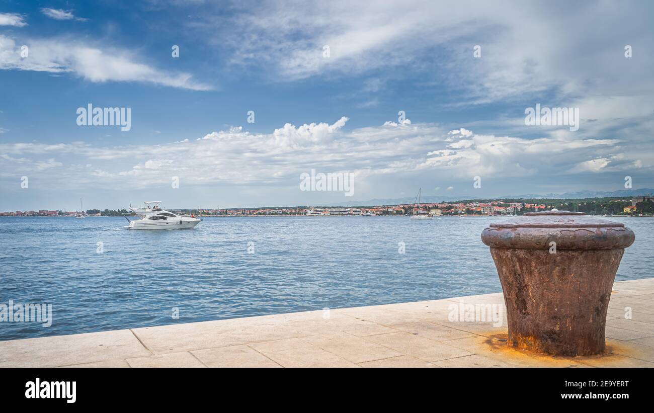 Motorboot Segeln in Zadar Bucht und Single, alt und rostig Liegeplatz Poller auf dem Pier. Adria und Zadar Stadt Küste, Kroatien Stockfoto