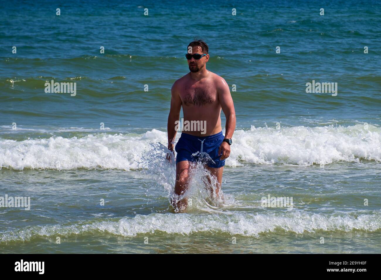 Junger Mann von mittlerer Baude kommt aus dem Meer Stockfoto