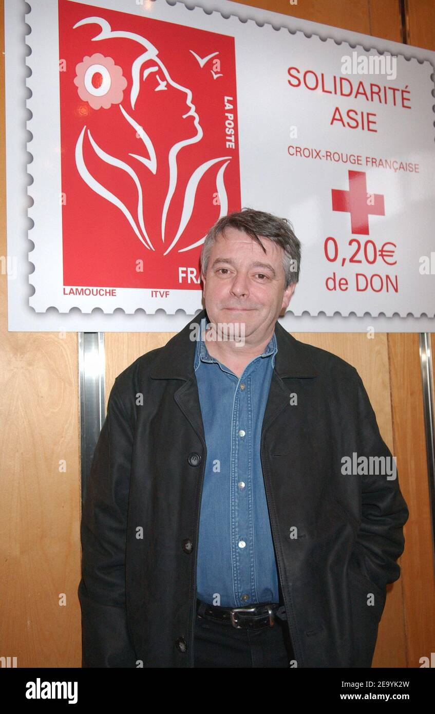 Der französische Designer Thierry Lamouche posiert vor der Marke 'Solidarite Asie', die er am 7. Januar 2005 im Finanzministerium in Paris, Frankreich, für das französische Rote Kreuz zur Unterstützung der Tsunami-Opfer in Südostasien geschaffen hat. Foto von Bruno Klein/ABACA. Stockfoto