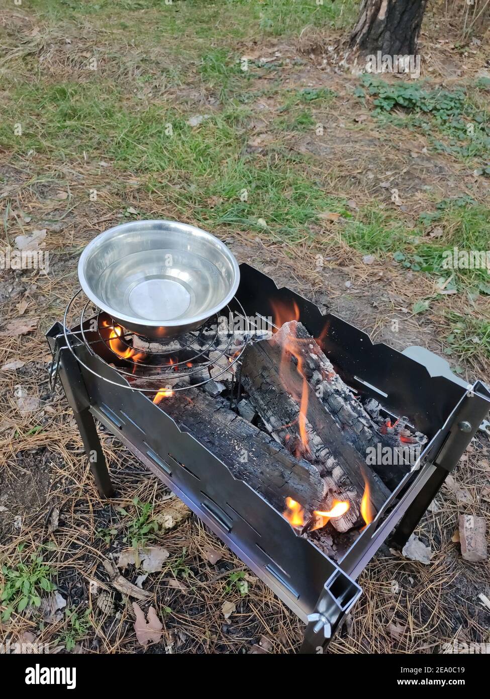 Eiserne Schüssel mit Wasser auf dem Feuer im Wald Beim Picknick Stockfoto