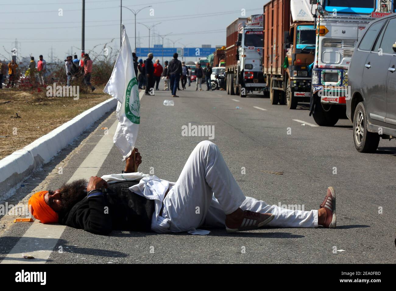 Neu Delhi. Februar 2021, 6th. Ein Landwirt legt sich bei einem Protest gegen neue Agrargesetze an der Grenze zwischen Neu-Delhi und dem indischen Bundesstaat Haryana nieder, 6. Februar 2021. Indische Behörden meldeten Alarm und versicherten am Samstag in der Hauptstadt Neu-Delhi die Sicherheit vor dem Aufruf der Bauern zur Chakka-Marmelade (Straßensperre). Quelle: Str/Xinhua/Alamy Live News Stockfoto