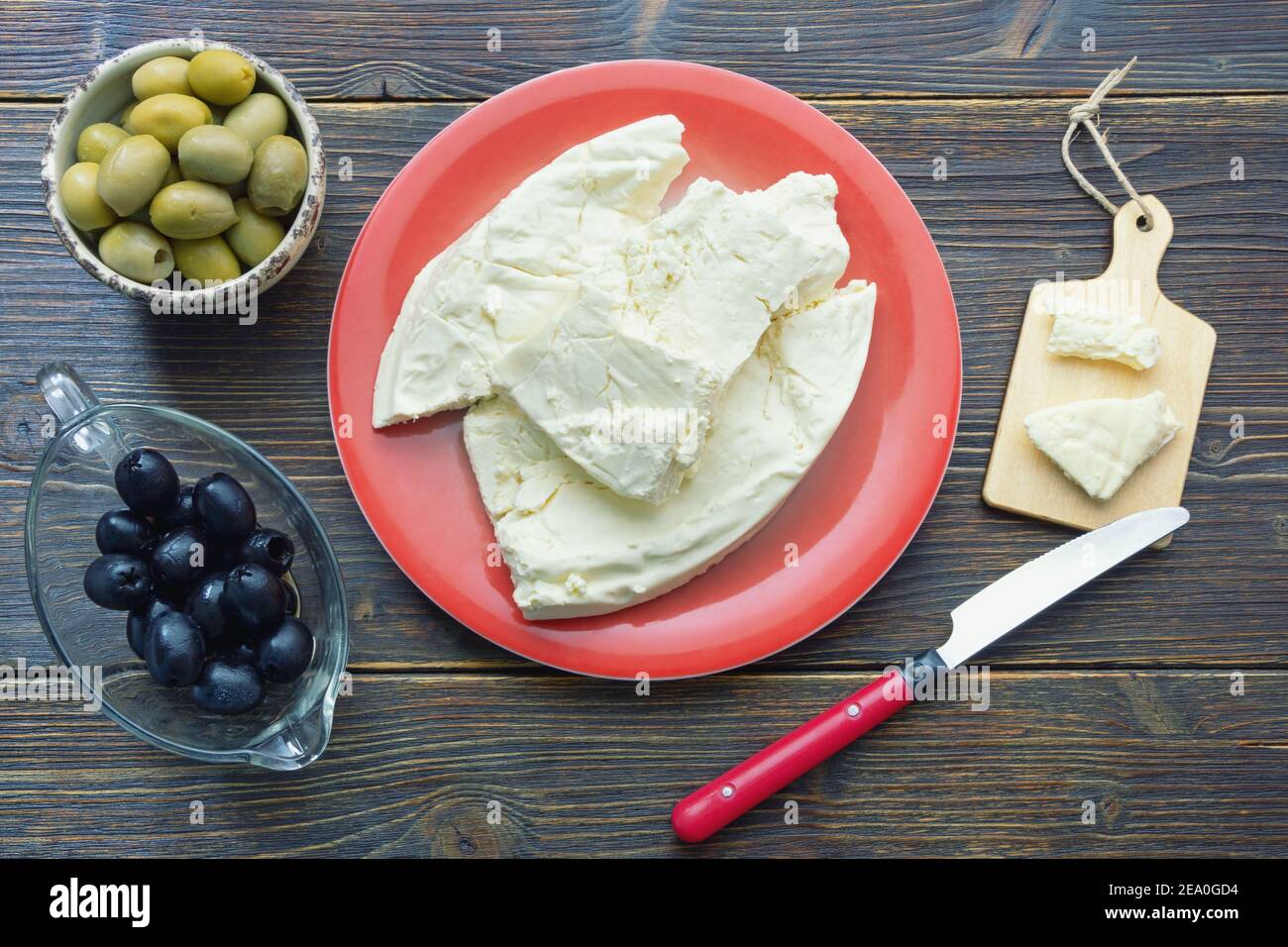 Balkan-Küche. Montenegro. Pljevaljski Cheese - lokaler Weichkäse in roter Platte auf dunklen rustikalen Tisch Stockfoto