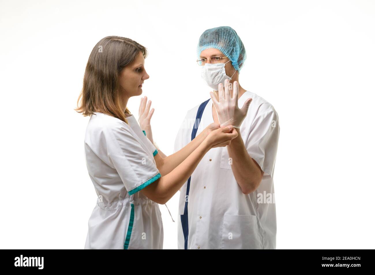 Eine Krankenschwester legt sterile medizinische Handschuhe auf die Hände des Chirurgen Stockfoto