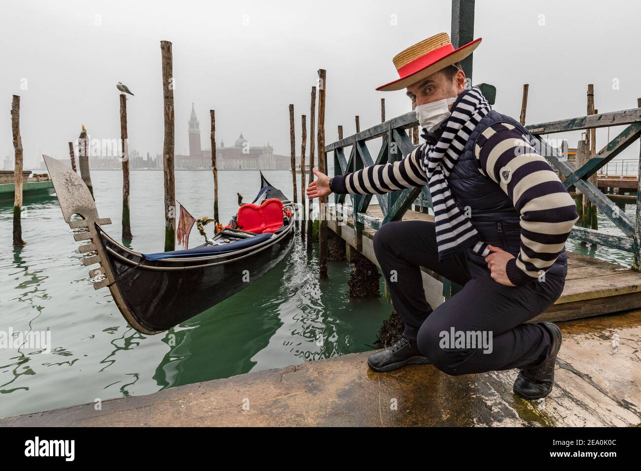 Gondolier begrüßt Sie an Bord seiner Gondel während Covid 19 Einschränkungen In Venedig Februar 2021 Stockfoto