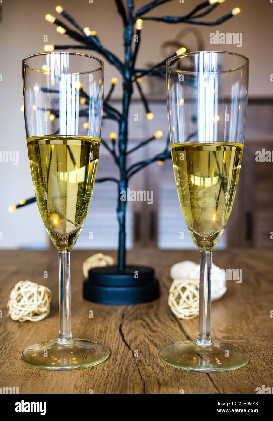 Zwei Gläser Weißwein und Lichter für eine Feier Stockfoto