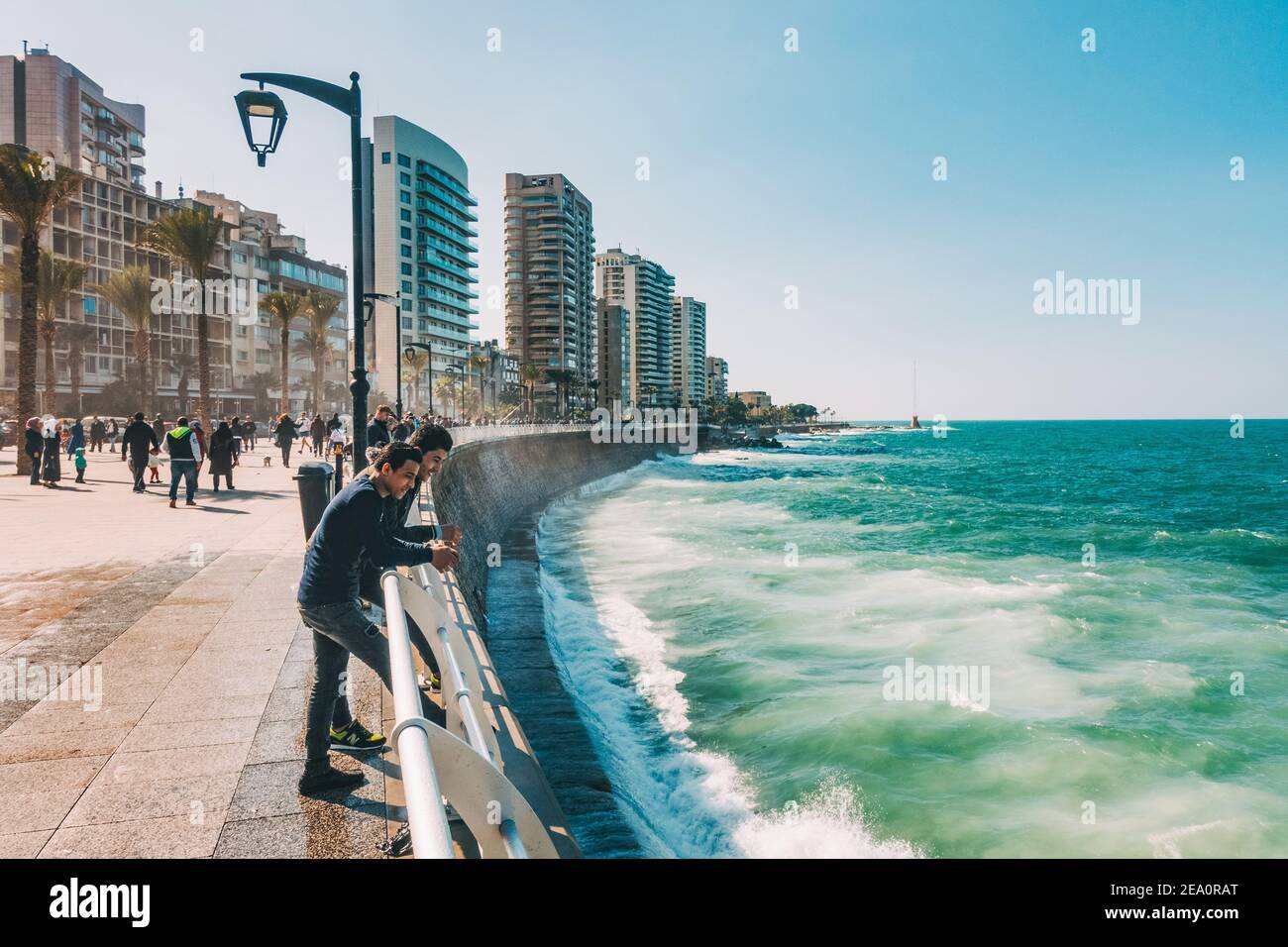 Zwei Männer halten an, um die Wellen eines Nachmittags auf der Corniche Beirut im Libanon zu beobachten Stockfoto