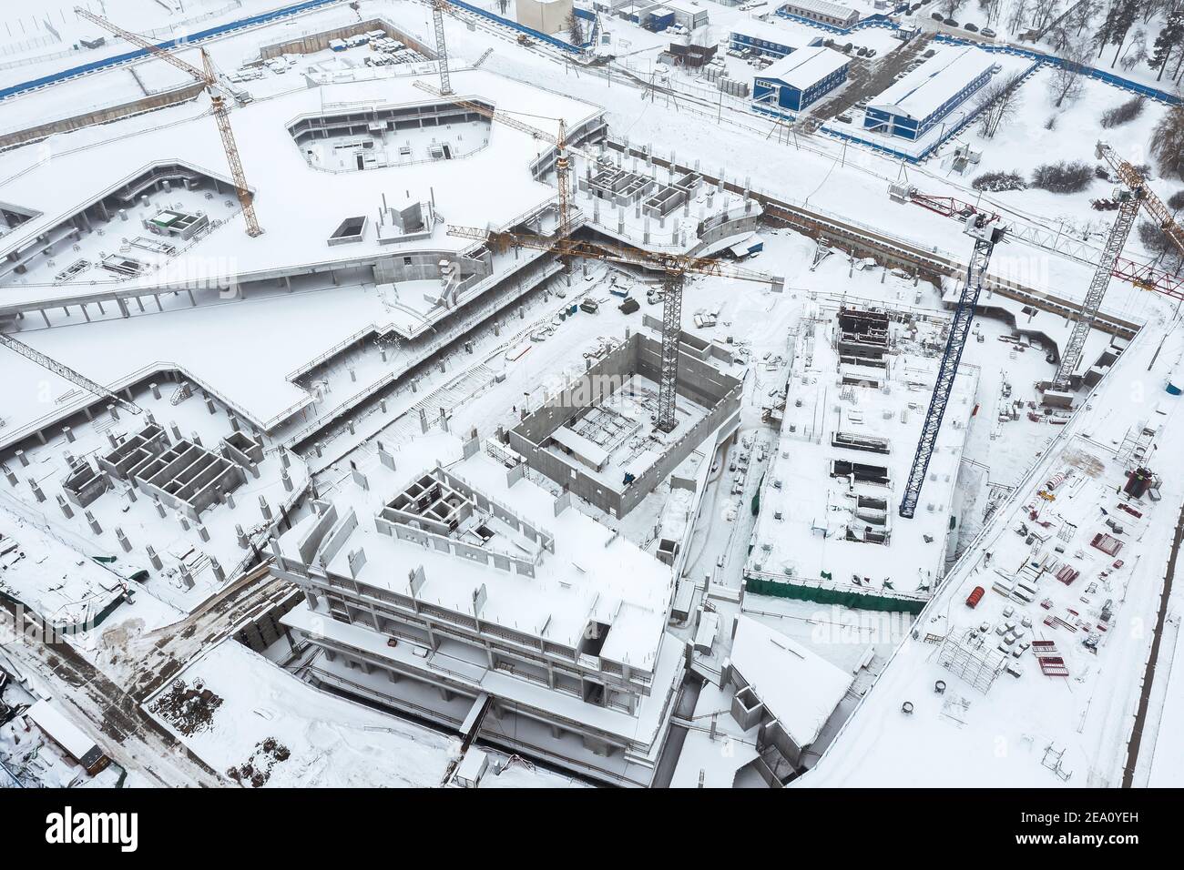 Luftaufnahme der städtischen Baustelle mit Arbeitskränen in Winterzeit Stockfoto