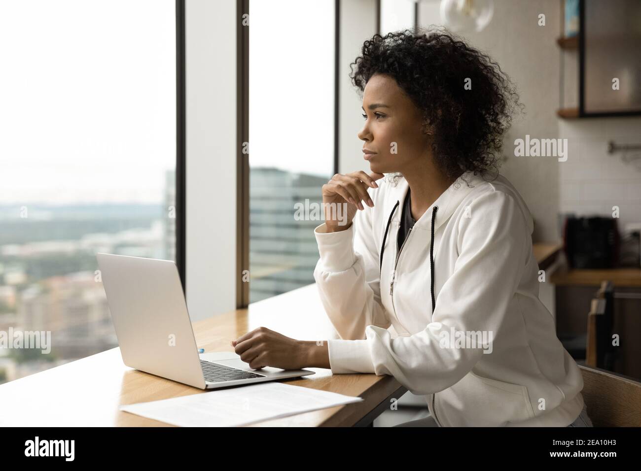 Millennial schwarze Frau sitzen von Laptop denken Blick auf Fenster Stockfoto
