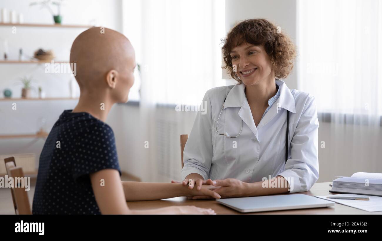 Glücklicher Arzt unterstützen haarlose weibliche Krebspatientin Stockfoto