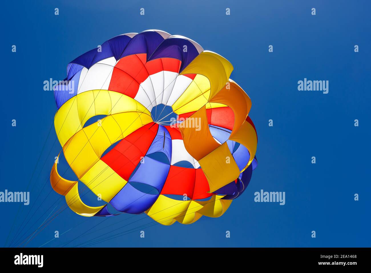 Der bunte Fallschirm fliegt hoch in den blauen Himmel Stockfoto