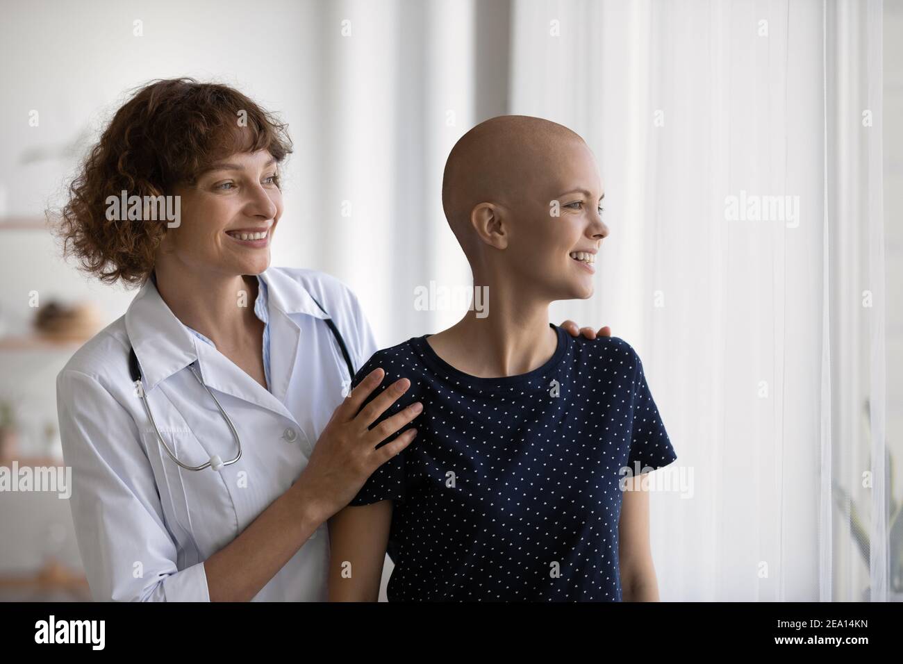 Lächelnder Arzt und haarlose Patientin hoffen auf Genesung Stockfoto