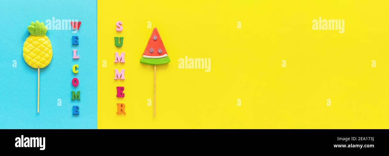 Willkommen Sommer bunten Text, Ananas und Wassermelone Lutscher auf Stick auf blaugelben Hintergrund. Konzept Urlaub oder Urlaub Kreativ Draufsicht Te Stockfoto