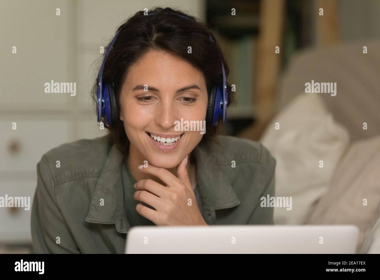 Glückliche Millennial Frau in Kopfhörer mit Laptop Stockfoto