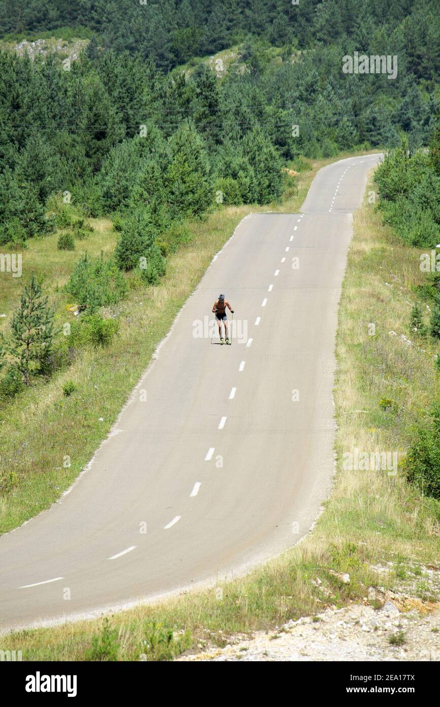 Ein Mann, der mit Rollski auf einer Bergstraße, Serbien, Ski fährt Stockfoto