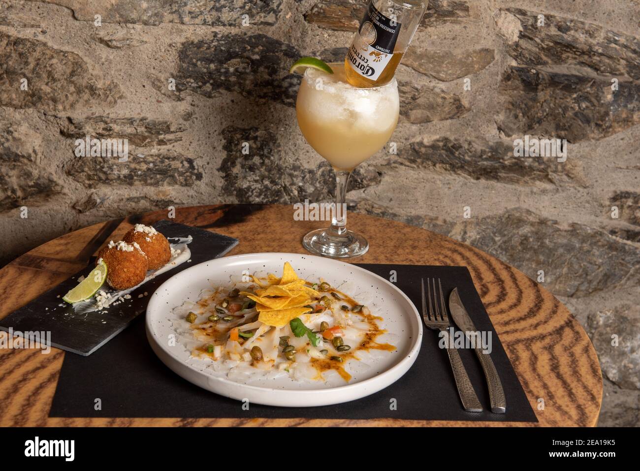 Arinsal, Andorra: 2021. Februar 4: Weißer Teller mit Cod Carpaccio mit Chili-Vinaigrette, Kürbiskernen und Chips. Stockfoto