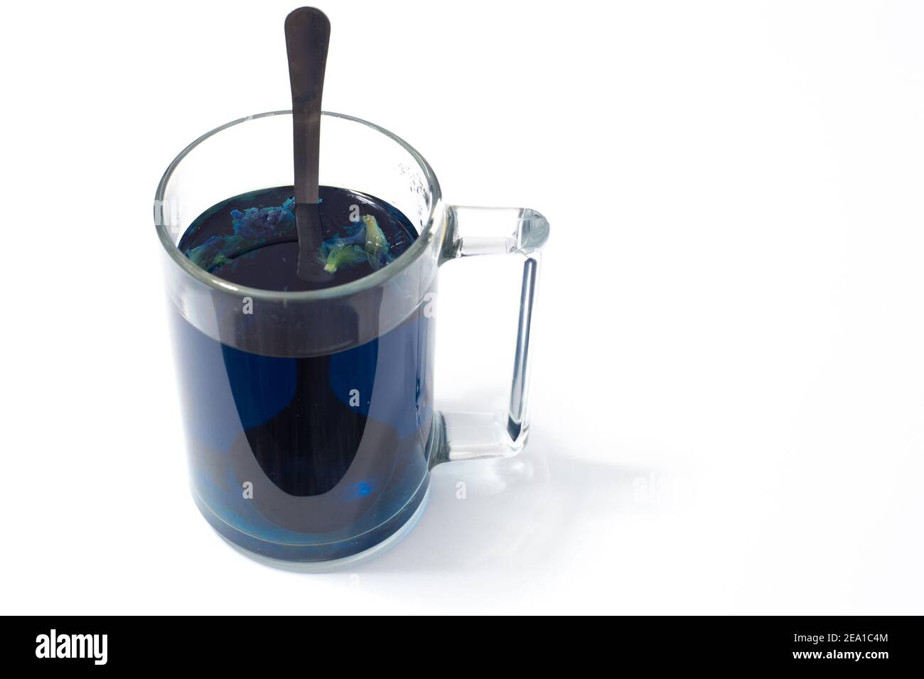 Thai blauer Tee in einem Glas Becher und Löffel auf Ein weißer isolierter Hintergrund Stockfoto