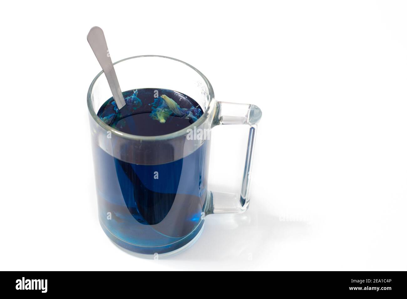 Thai blauer Tee in einem Glas Becher und Löffel auf Ein weißer isolierter Hintergrund Stockfoto