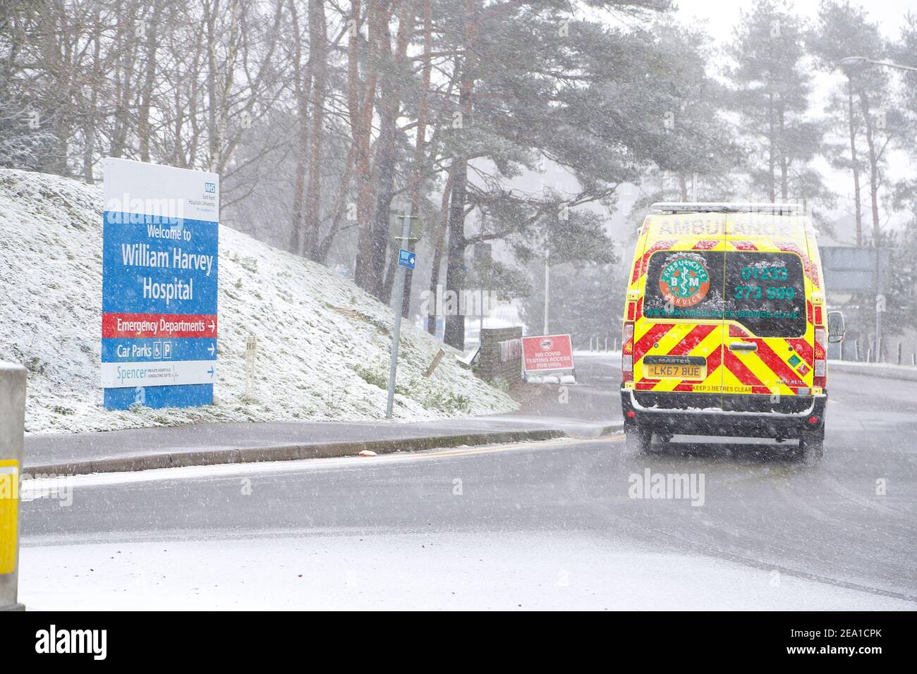 Ashford, Kent, Großbritannien. Februar 2021, 07. UK Wetter: Sturm Darcy trifft die Stadt Ashford in Kent. Ein schneebedeckter Krankenwagen kommt im William Harvey Krankenhaus an. Foto-Kredit: Paul Lawrenson/Alamy Live Nachrichten Stockfoto