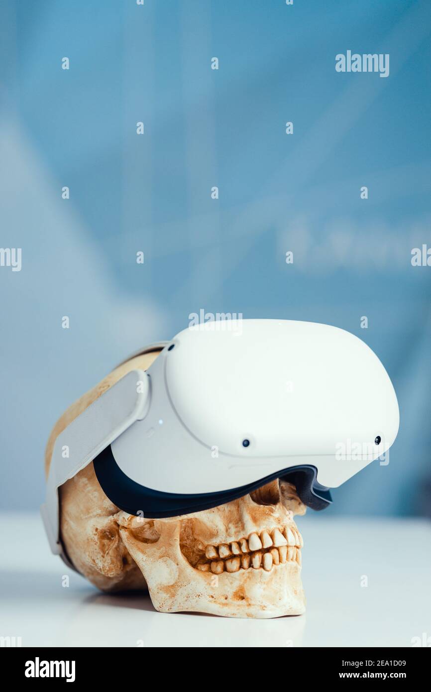 VR-Helm auf einem menschlichen Schädel den Schaden der virtuellen Realität für die menschliche Gesundheit. Stockfoto