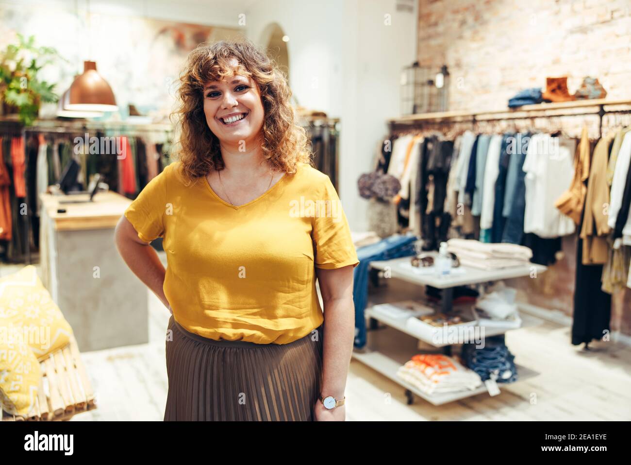 Porträt der weiblichen Modehaus Besitzer. Frau im Modeladen stehend und lächelnd. Stockfoto