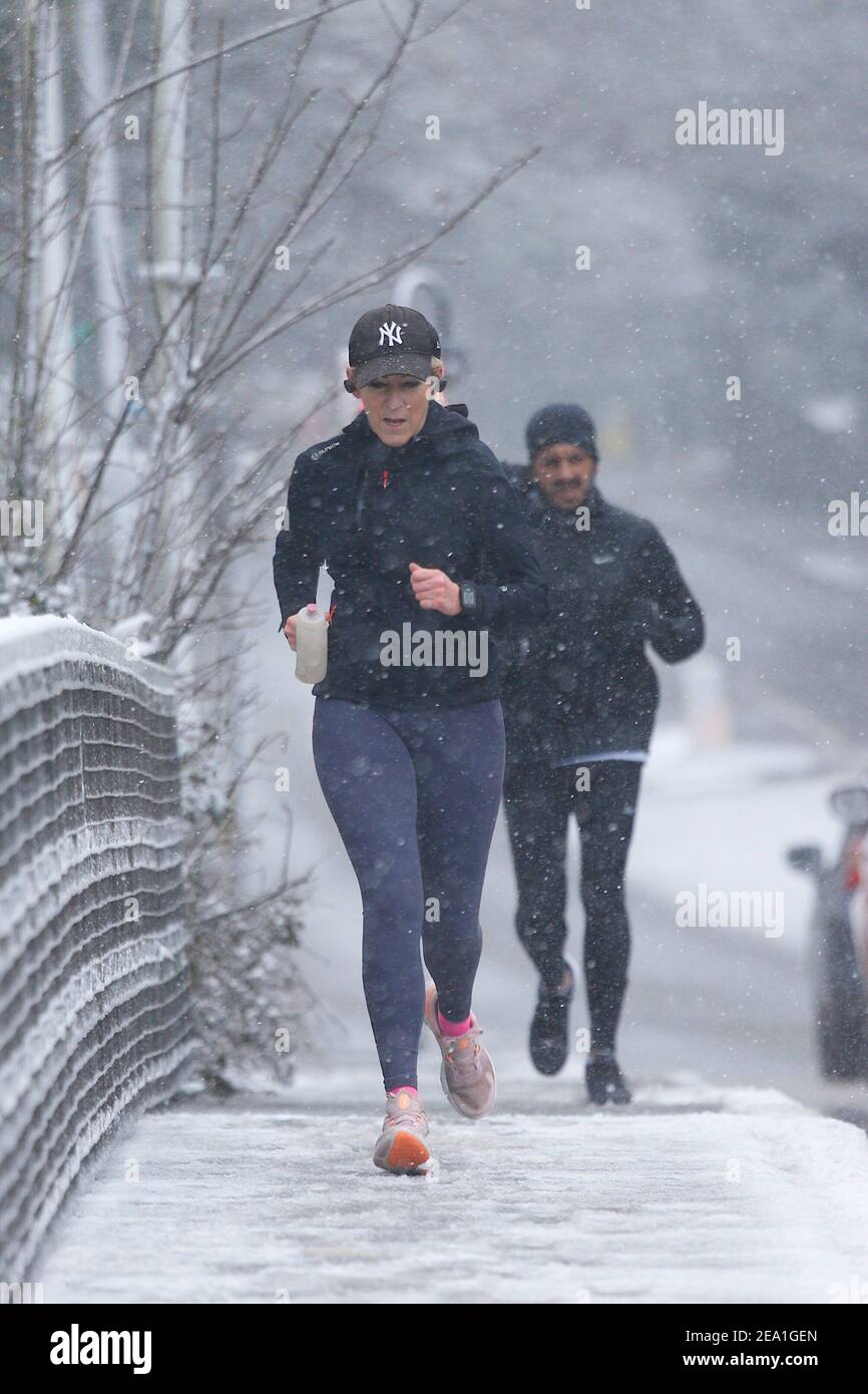 Ashford, Kent, Großbritannien. Februar 2021, 07. UK Wetter: Sturm Darcy trifft die Stadt Ashford in Kent. Trotz des Schnees hält eine Joggerin ihre Fitness aufrecht. Foto-Kredit: Paul Lawrenson/Alamy Live Nachrichten Stockfoto