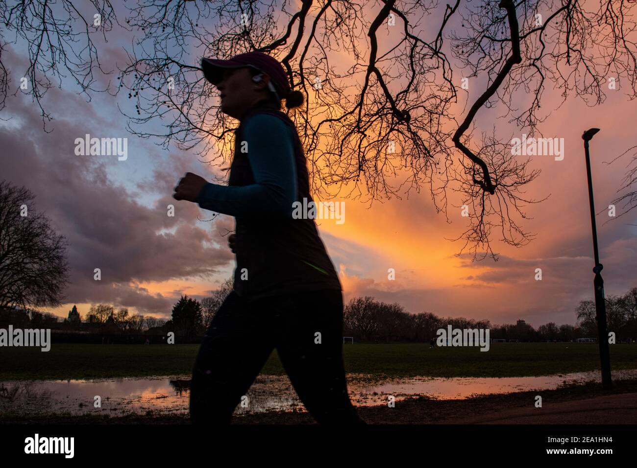 Sonnenuntergang in einem Londoner Park, während die Leute sich für einen Laufen während Lockdown in 2021 Stockfoto