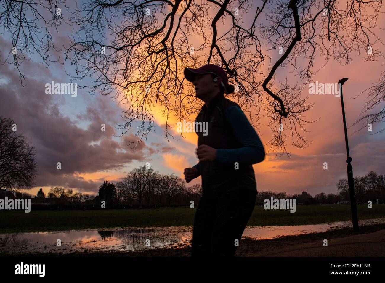 Sonnenuntergang in einem Londoner Park, während die Leute sich für einen Laufen während Lockdown in 2021 Stockfoto