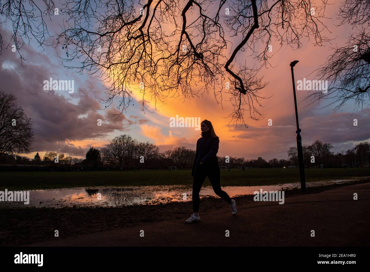 Sonnenuntergang in einem Londoner Park, während die Leute sich für einen Gehen Sie während des Lockdown im Jahr 2021 Stockfoto