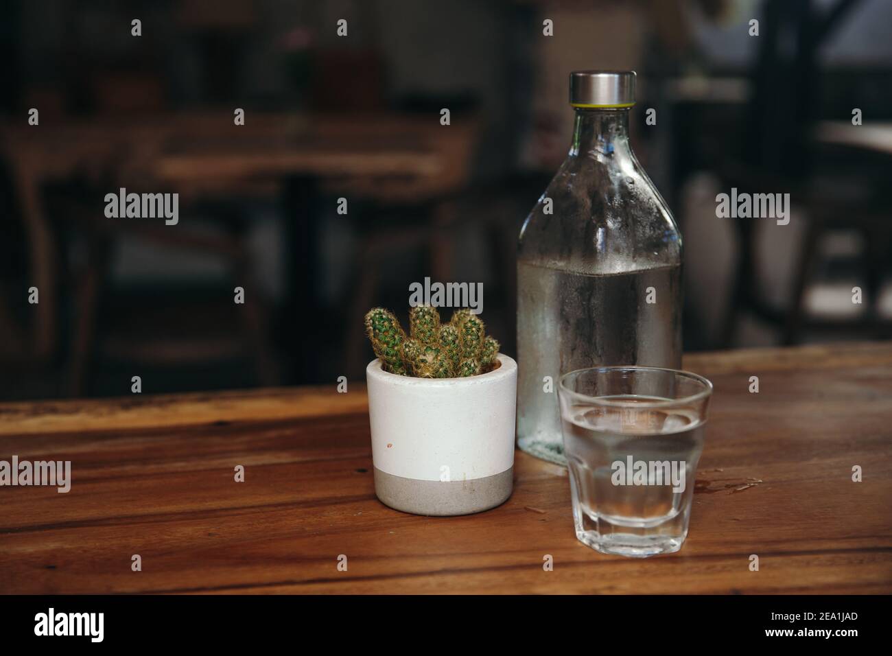 Trinkwasser. Glas Wasser mit einer Flasche am Tisch Stockfoto