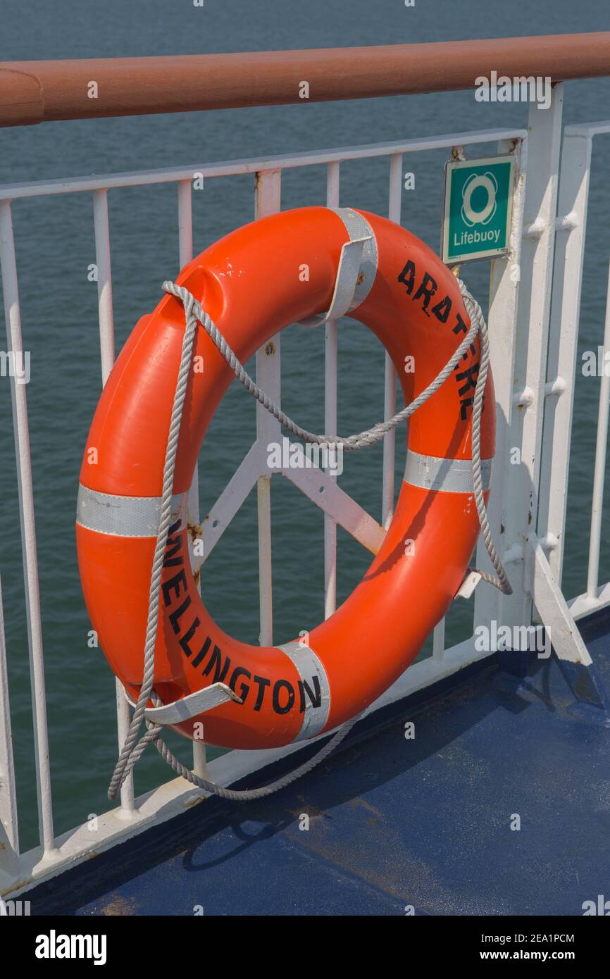 Orangefarbener Rettungsgurt an Deck der Cook Strait Fähre mit Sicherheitsschnur. Sicherheitsflotationsvorrichtung, die an Geländern befestigt ist, falls jemand umfällt Stockfoto