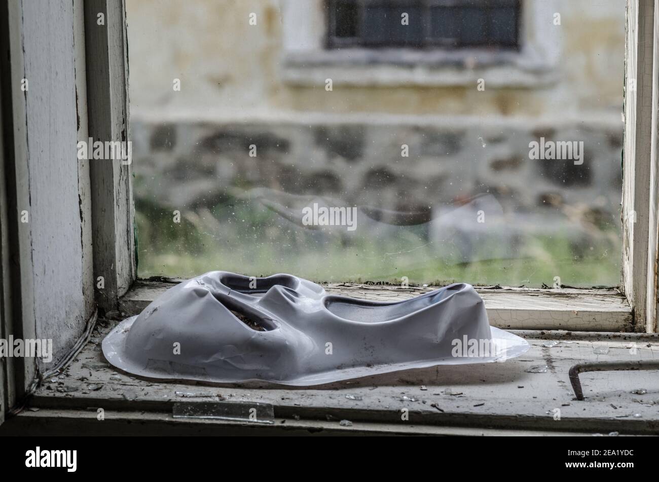 Weiße Horror Maske auf Fenster der Fabrik Stockfoto