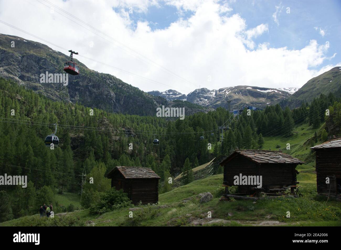 Schweizer Berghütten unter den Gondeln der Seilbahn. Stockfoto