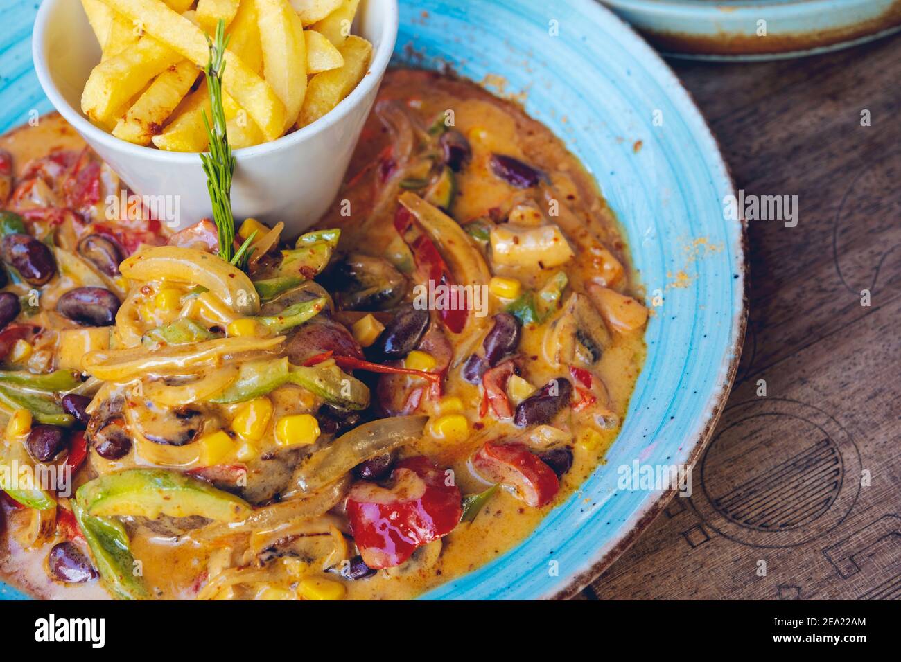 FAJITAS mit farbigen Paprika und Zwiebeln, serviert mit Pommes, Salsa und saurer Sahne. Stockfoto