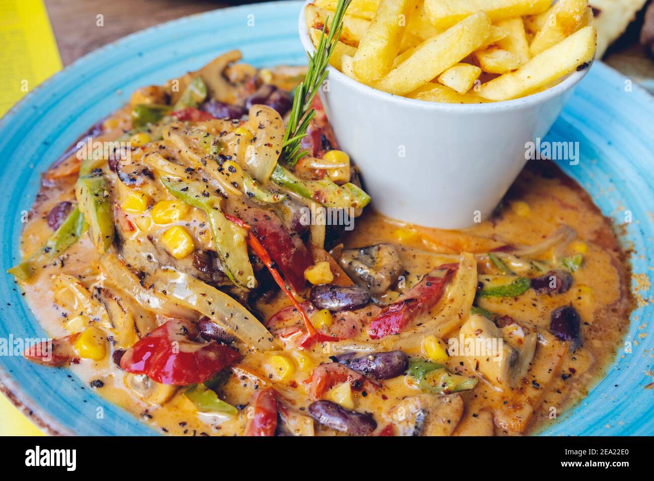 FAJITAS mit farbigen Paprika und Zwiebeln, serviert mit Pommes, Salsa und saurer Sahne. Stockfoto