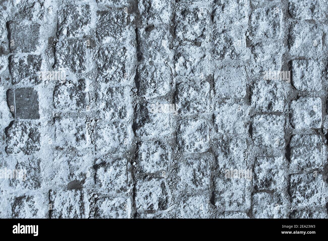 Schwarze und weiße Pflastersteinpflaster Textur. Nahaufnahme von Blöcken. Blau getöntes Bild. Stockfoto
