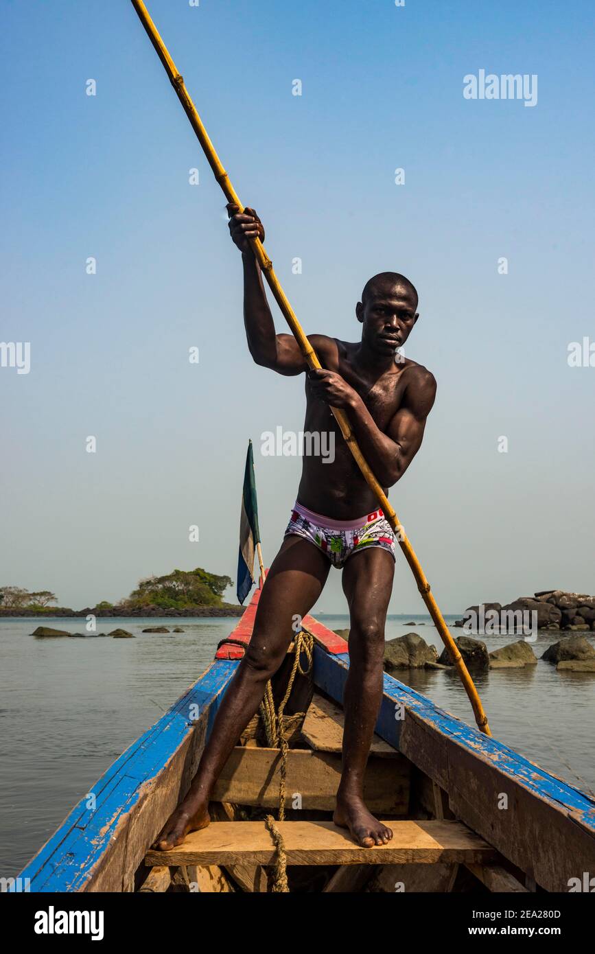 Mann schiebt sein kleines Boot auf Banana Inseln, Sierra Leone Stockfoto