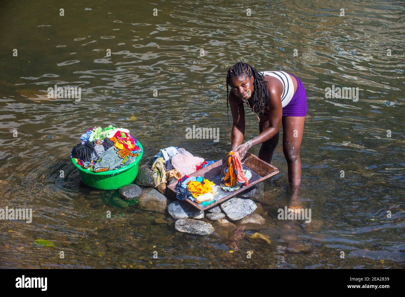 Frau, die ihre Kleidung in einem Fluss an der Ostküste von Sao Tome, Sao Tome und Principe, Atlantischer Ozean wäscht Stockfoto