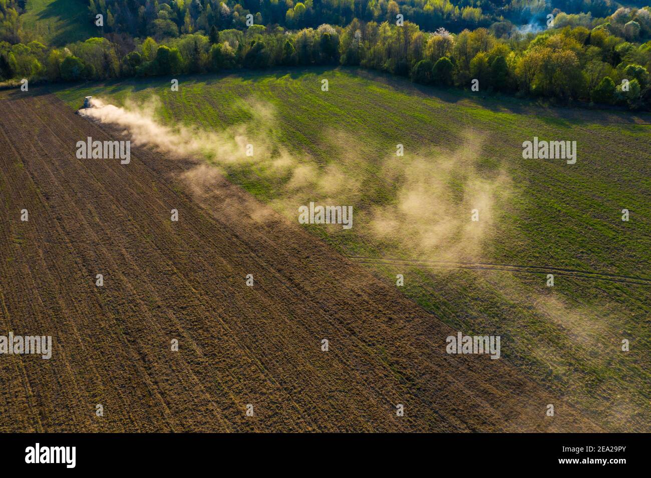 Ukrainische Felder werden von einem Traktor kultiviert, das Feld wird vor der Aussaat Getreide angebaut, Draufsicht, ein Wald kann auf dem horizon,2021 gesehen werden Stockfoto