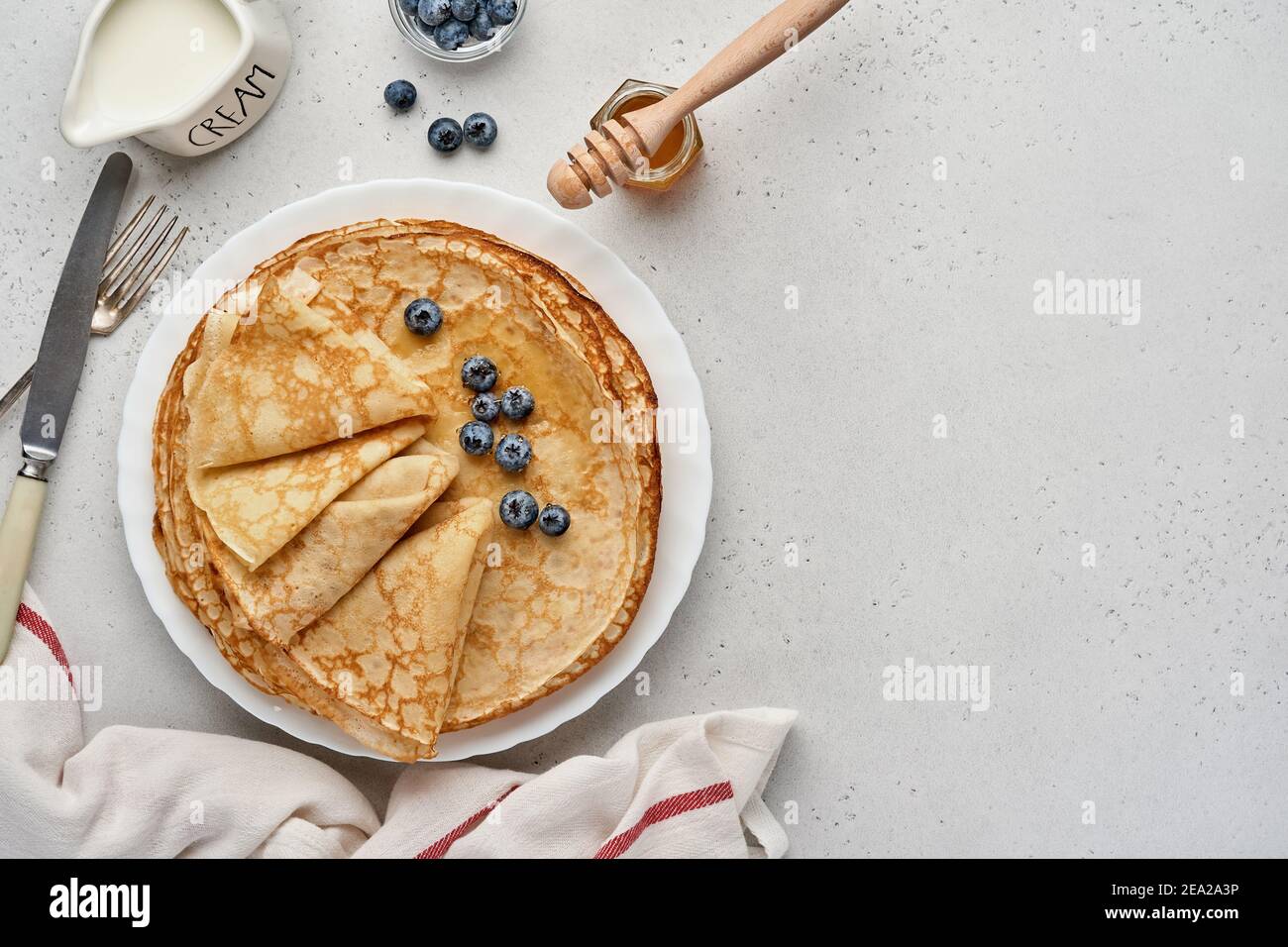Crepes, dünne Pfannkuchen oder Blini mit Beeren auf weißem Teller ...