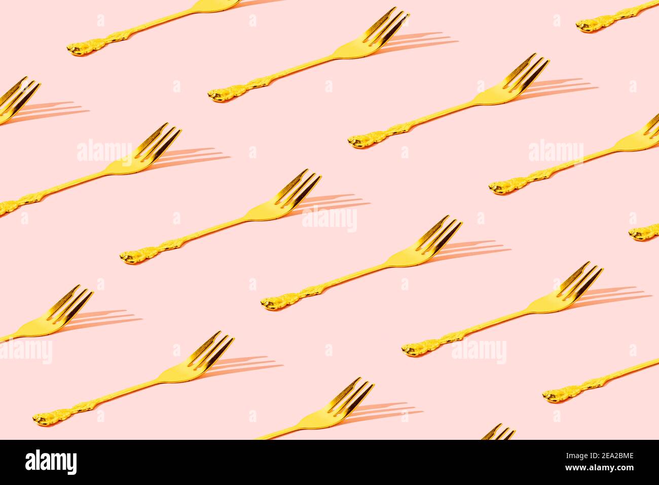 Muster aus Goldgabel mit schönem pastellrosa Hintergrund. Minimal Feier Party Konzept Kunst Stockfoto